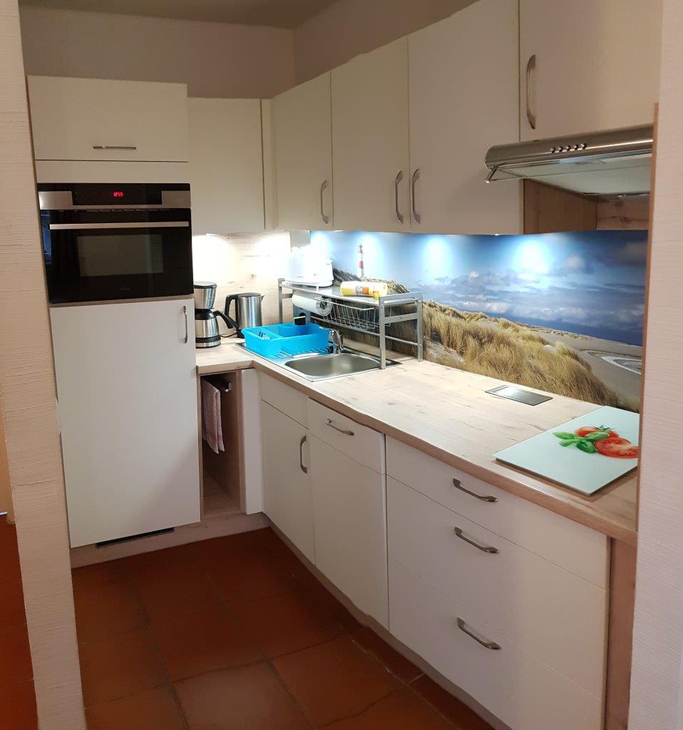 Mit Backofen/ Mikrowelle, Ceranfeldkochplatte, Kühlschrank incl. Gefrierfach, Geschirrspüler, Kaffeemaschine, Wasser- und Eierkocher.